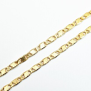 May include: A gold chain necklace with a textured, mariner link design.