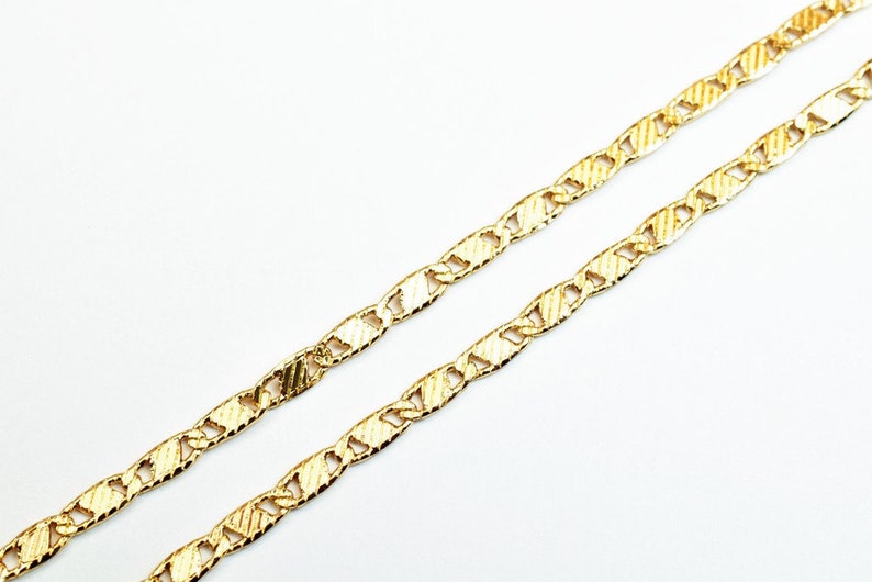 May include: A gold chain necklace with a textured, mariner link design.