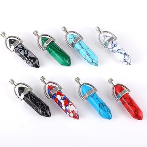 May include: Eight gemstone pendants with silver-colored metal bails. The pendants are various colors, including black with white spots, green, turquoise, white with black veining, black with white veining, red with white and blue spots, light blue, and red.