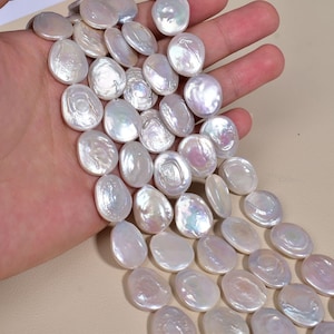 Può includere: Una collana di perle d'acqua dolce bianche e iridescenti a forma di moneta. Le perle sono infilate su un filo trasparente e hanno un diametro di circa 2,5 cm.