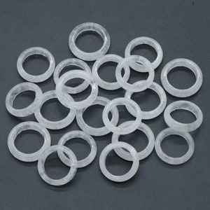 May include: A pile of white jade rings, each ring is smooth and polished. The rings are all different sizes and shapes, but they are all made of the same material.