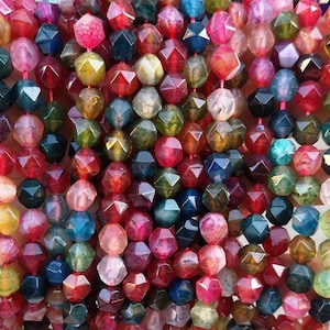 May include: A strand of multi-coloured faceted agate beads. The beads are a mix of red, green, blue, and yellow. Each bead has a star-shaped pattern.
