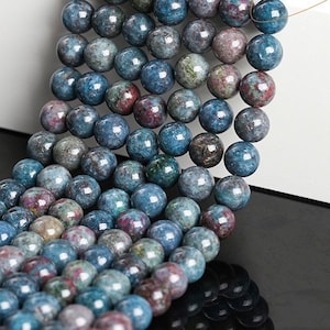 May include: A strand of blue, green, and pink gemstone beads. The beads are round and have a smooth, polished finish.