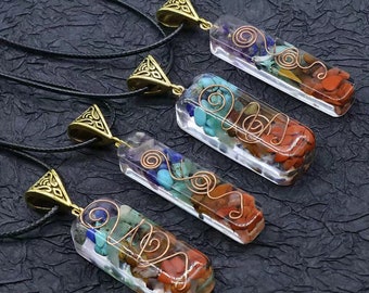 May include: Four rectangular pendants with a variety of colorful stones encased in clear resin. Each pendant has a gold-colored bail and is strung on a black cord. Copper wire swirls around the stones.