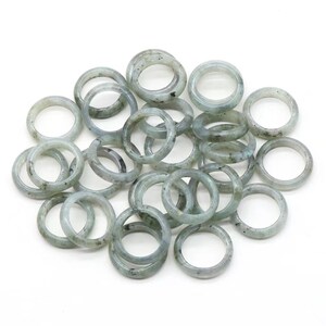 May include: A pile of 20 smooth, light green gemstone rings. The rings are made of labradorite and are perfect for jewelry making.