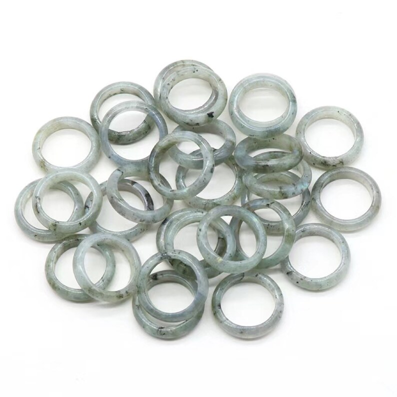 May include: A pile of 20 smooth, light green gemstone rings. The rings are made of labradorite and are perfect for jewelry making.