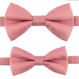 May include: Two pink bow ties, one larger than the other, against a white background. The larger bow tie is positioned above the smaller bow tie. The text "Made in France" is visible in the top right corner of the image.
