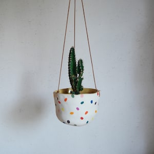 Peut inclure: Ensemble de trois mugs en céramique avec une finition mate et mouchetée. Les tasses sont de couleur crème, marron clair et marron foncé. Design simple et minimaliste, idéal pour le café ou le thé.