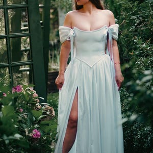 white renaissance corset dress walking in garden
