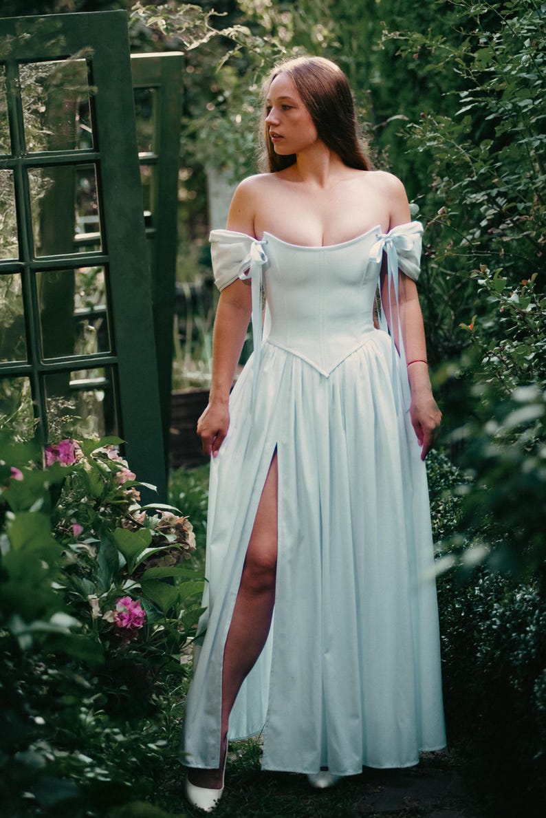 white renaissance corset dress walking in garden