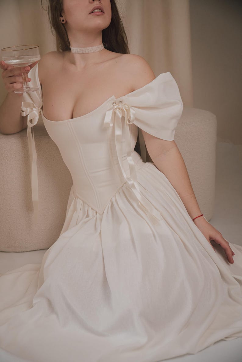 ivory linen wedding dress with corset bodice and off shoulder bow sleeves