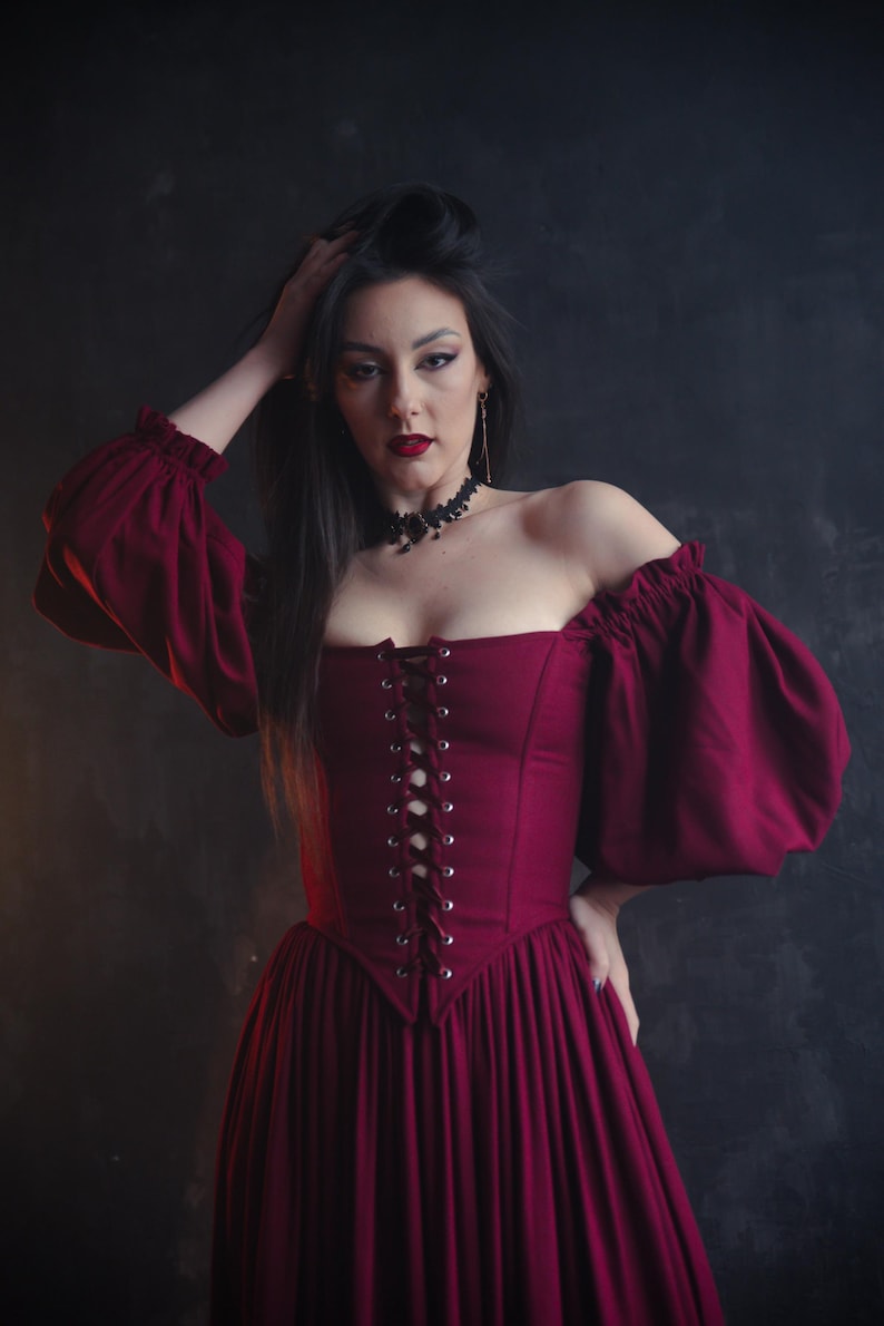 Renaissance burgundy corset dress with puff sleeves and flowing skirt