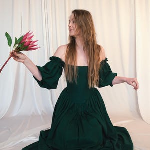 emerald green dress holding flowers cottagecore style