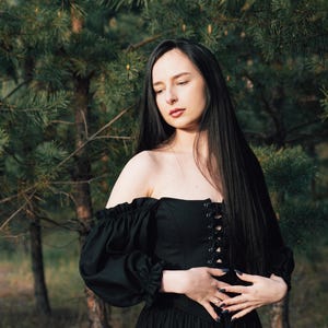 Black off the shoulder corset dress styled for forest wedding or fantasy photoshoot