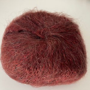 May include: A ball of deep red yarn with a fuzzy texture.