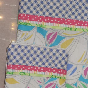 Puede incluir: Dos estuches con cremallera con un estampado floral y geom&eacute;trico. La parte superior de los estuches presenta un dise&ntilde;o a cuadros azul y blanco. Debajo, se ven una cinta rosa de lunares y una cinta verde. El estuche m&aacute;s grande tiene un cierre plateado.