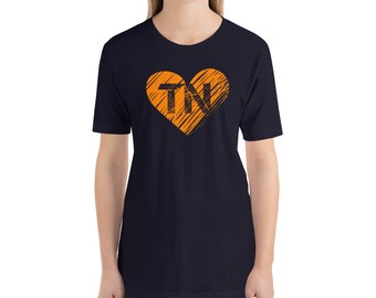 Könnte beinhalten: Ein marineblaues T-Shirt mit einem orangefarbenen Herz-Motiv, das die Buchstaben "TN" in Schwarz zeigt.