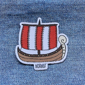 May include: An embroidered patch depicting a Viking ship in red and white with the word "NORWAY" underneath.