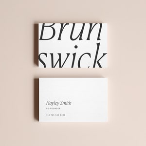 May include: Two white business cards with black text. The top card has the text "Brunswick" in a stylized font. The bottom card has the text "Hayley Smith, Co-Founder, +44 765 943 3220".