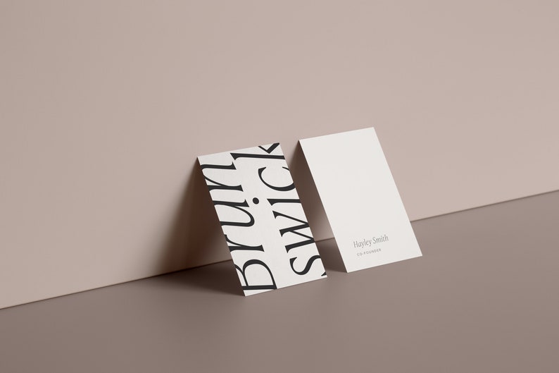 May include: Two white business cards, one with a black and white graphic design featuring the word "black" repeated in a stylised font and the other with the text "Hayley Smith, Creative Director".