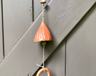 Unique handpinched orange ceramic bell, making a bright sound. Artisan wallhanging.