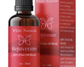 Könnte beinhalten: Eine braune Glasflasche mit schwarzem Verschluss und einem weißen Etikett mit der Aufschrift "White Naturals Rejuvenate 100% Pure Oil Blend 1 oz / 30ml". Die Flasche steht neben einer roten Schachtel mit weißem Text, auf der "White Naturals Rejuvenate 100% Pure Oil Blend 1 oz / 30ml" steht. Die Schachtel enthält auch eine Liste der Vorteile und Anweisungen zur Verwendung des Öl-Gemischs.