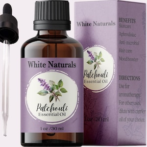 Könnte beinhalten: Eine 30 ml Flasche Patchouli-Ätherisches Öl von White Naturals. Die Flasche ist aus braunem Glas mit einer Tropfpipette und einem violetten Etikett mit einem floralen Design. Das Etikett enthält auch den Text "Patchouli Essential Oil" und "1 oz / 30 ml". Die Flasche befindet sich neben einer violetten Schachtel mit dem Text "White Naturals" und "Patchouli Essential Oil" auf der Vorderseite. Die Schachtel listet auch die Vorteile von Patchouli-Ätherischem Öl auf, darunter Hautpflege, Aphrodisiakum, antimikrobiell, Haarpflege und Stimmungsaufheller. Die Schachtel enthält auch Gebrauchsanweisungen.