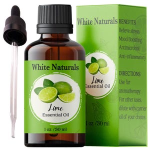 Op de afbeelding: Een bruine glazen fles met een druppelaar gevuld met limoenolie. De fles is gelabeld met "White Naturals Lime Essential Oil 1 oz / 30 ml". Het etiket bevat ook een groene achtergrond met een limoenplak en bladeren. De fles staat naast een wit en groen etiket met de tekst "White Naturals Lime Essential Oil 1 oz / 30 ml" en een lijst met voordelen en gebruiksaanwijzingen.