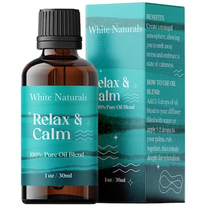 May include: A brown glass bottle with a black cap, labeled "White Naturals Relax & Calm 100% Pure Oil Blend 1 oz / 30ml". The bottle is next to a box with the same label and text, "BENEFITS Create a tranquil atmosphere, allowing you to melt away stress and embrace a state of calmness. HOW TO USE OIL BLEND: Add 3-5 drops of oil blend to your diffuser filled with water or apply 1-2 drops to your palms, rub together, then inhale deeply for relaxation."