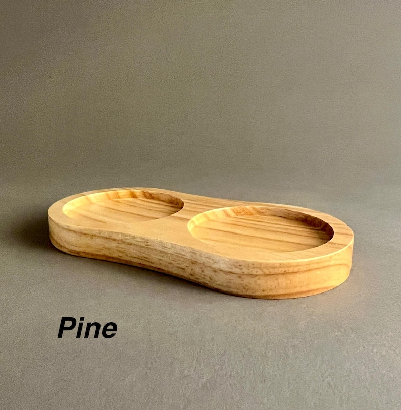 May include: A wooden serving tray with two circular depressions. The tray is made of pine wood and has a natural wood finish.  Pine.