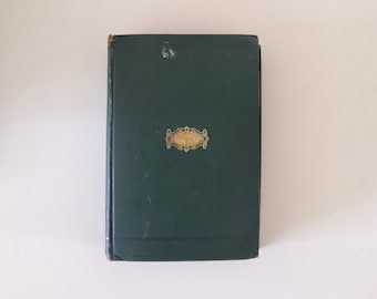 May include: A dark green hardback book with a gold embossed design on the front cover.
