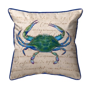 May include: Square throw pillow featuring a blue crab illustration with green and blue accents. The crab is set against a backdrop of aged parchment with script writing and a dark blue border. Coastal decor.