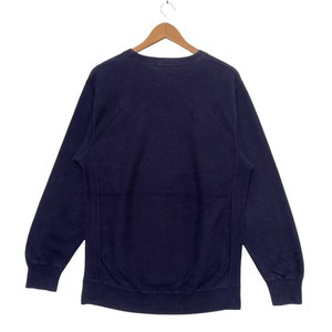 May include: A navy blue sweatshirt with long sleeves and a crew neck.