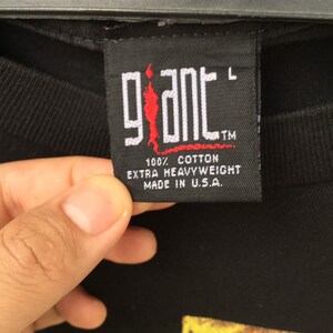 May include: Black tag with white text that reads "giant" in a stylized font. The tag also says "100% cotton extra heavyweight made in U.S.A." and has a size label that says "L".
