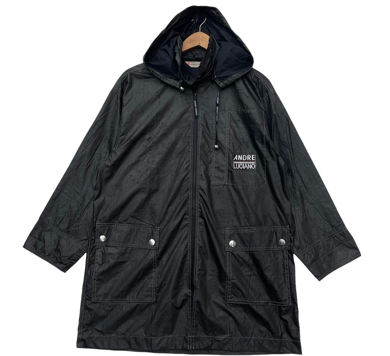 May include: A black hooded jacket with a zip fastening and two front pockets. The jacket has the text "ANDRE LUCIANO" embroidered on the front.