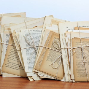 Pode incluir: Uma pilha de p&aacute;ginas de livros antigos amarradas com barbante. As p&aacute;ginas s&atilde;o de cor creme e t&ecirc;m texto preto impresso nelas. As p&aacute;ginas est&atilde;o dispostas em ordem aleat&oacute;ria e algumas das p&aacute;ginas t&ecirc;m vincos e rasgos vis&iacute;veis.