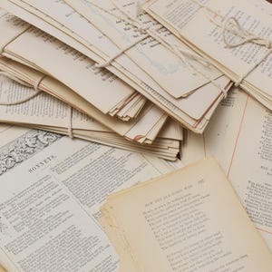 May include: A stack of vintage books tied with twine, featuring poems by William Shakespeare and Sir Walter Scott. The books have aged paper and a worn, antique aesthetic.
