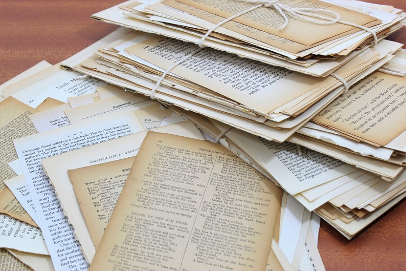Pode incluir: Uma pilha de p&aacute;ginas de papel velhas, amareladas e desgastadas com texto impresso nelas. As p&aacute;ginas est&atilde;o amarradas com um barbante. As p&aacute;ginas est&atilde;o dispostas em uma pilha, com algumas p&aacute;ginas que sobressaem dos lados. As p&aacute;ginas est&atilde;o sobre uma superf&iacute;cie de madeira.