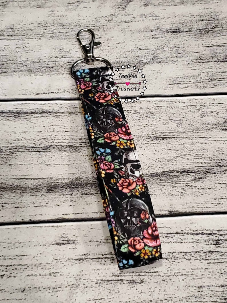 May include: A black and white fabric key chain with a floral pattern and a Darth Vader image. The key chain has a silver metal clip. The text "TeeNee Treasures" is visible in the image.