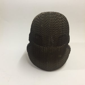 May include: A brown cardboard sculpture of a face. The sculpture is made of corrugated cardboard and has a textured surface.