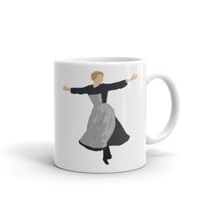 May include: White ceramic mug featuring a black and grey illustration of a woman in a dress with her arms outstretched.