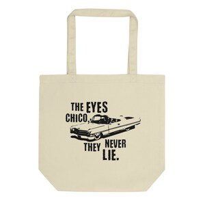 May include: A beige tote bag featuring a black graphic of a classic car and the text "THE EYES CHICO, THEY NEVER LIE."