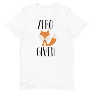 May include: White t-shirt with a black and orange fox illustration and the text "ZERO GIVEN" printed on it.