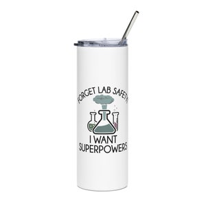 May include: White stainless steel tumbler with a black and white graphic that says "Forget Lab Safety I Want Superpowers". The graphic includes a cartoon image of a beaker, test tubes, and a cloud of smoke.