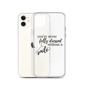 May include: Clear phone case with a black graphic that says "you're never fully dressed without a smile" and a hanger with a smile on it.