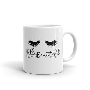 Puede incluir: Taza de café de cerámica blanca con un diseño negro de dos ojos cerrados con pestañas y el texto "Hello Beautiful".