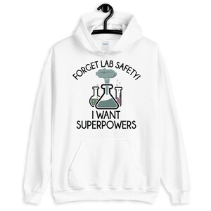 May include: White hoodie with a black graphic of beakers and a cloud of smoke. The text reads "Forget Lab Safety! I Want Superpowers".