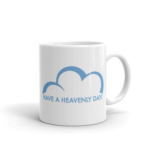 Puede incluir: Taza de cerámica blanca con un gráfico de nube azul y el texto "HAVE A HEAVENLY DAY!"