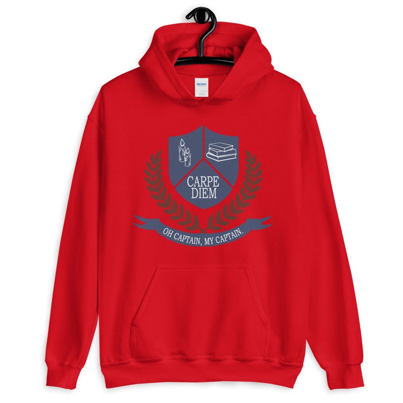 May include: Red hooded sweatshirt with a blue crest featuring a stack of books, candles, and the text "Carpe Diem". The crest is surrounded by a laurel wreath and the text "Oh Captain, My Captain".