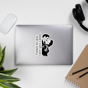 May include: Black and white sticker featuring a silhouette of a couple kissing with the text "Frankly my dear, I don't give a damn."